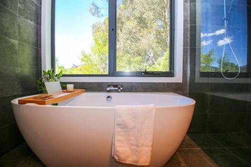 a bath tub in a bathroom with a window at Apex Villa in Bright