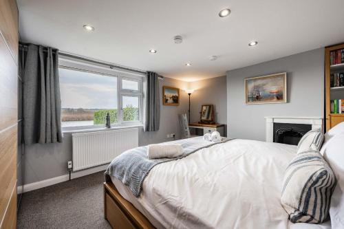 a bedroom with a bed and a window at Riverside Cottage - Norfolk Holiday Properties in Reedham
