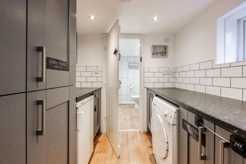 a kitchen with a washer and dryer at Riverside Cottage - Norfolk Holiday Properties in Reedham