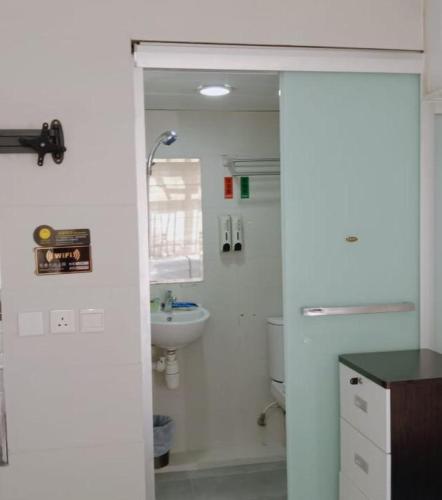 a white bathroom with a sink and a toilet at 金源賓館 Golden Yuan Guest House in Hong Kong