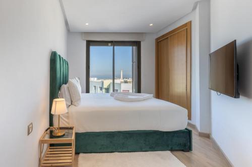 - une chambre avec un grand lit et une grande fenêtre dans l'établissement ANFA LIVING - LES TERRASSES D'ANFA # Front Sea VIEW 180 - 2 or 3 bedrooms, à Casablanca