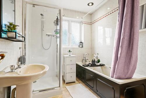y baño con bañera, lavamanos y ducha. en Greenford Hububb Stay, en Northolt
