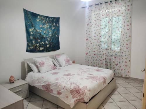 um quarto com uma cama com flores cor-de-rosa em Ca' Allegra - Centro em Asti
