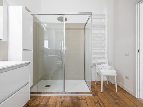 uma cabina de duche em vidro numa casa de banho branca com um banco em Villa Mika em Capitana