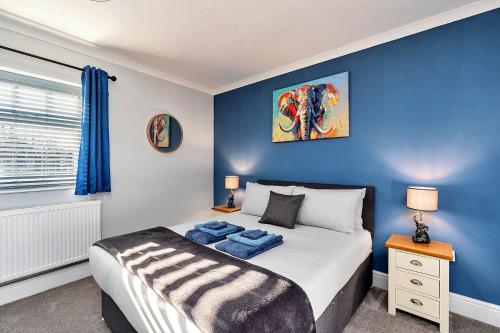 una camera con un letto con una parete blu di Finest Retreats - South Barn a Winestead