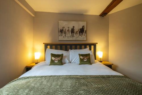 um quarto com uma cama com dois gatos nas almofadas em Charming 2 bedroom property em Bury Saint Edmunds