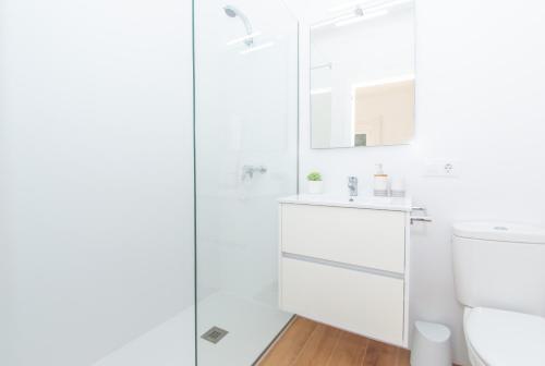 a white bathroom with a sink and a shower at Villa Jomar by Sonne Villas in Cala Galdana
