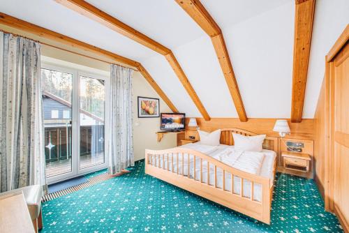 ein Schlafzimmer mit einem Bett und einem großen Fenster in der Unterkunft Hotel Nuss in Grainau