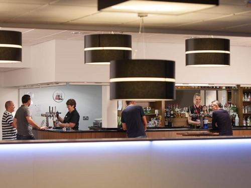 un groupe de personnes debout au bar dans l'établissement Fire Service College, à Moreton-in-Marsh