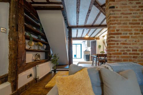 a living room with a couch and a brick wall at Charming 2 bedroom property in Bury Saint Edmunds