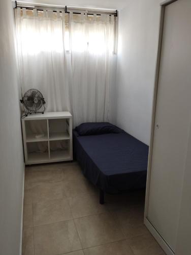 Apartamento en Barcelona في برشلونة: غرفة نوم صغيرة بها سرير ونافذة