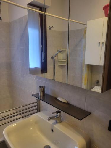 ein Bad mit einem Waschbecken und einem Spiegel in der Unterkunft MIRABELLO in Verbania