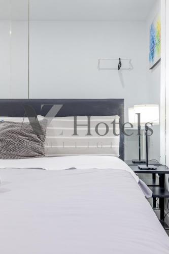 a white bed in a room with a hot sign on it at AYZ Ulises - Auto check-in property in Madrid