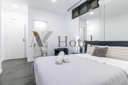 a white bedroom with two beds and a staircase at AYZ Ulises - Auto check-in property in Madrid