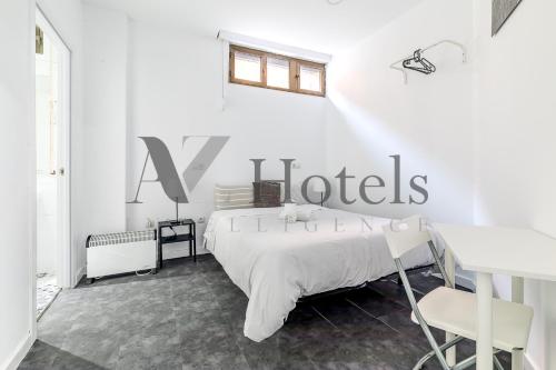 a white bedroom with a bed and a sign on the wall at AYZ Ulises - Auto check-in property in Madrid