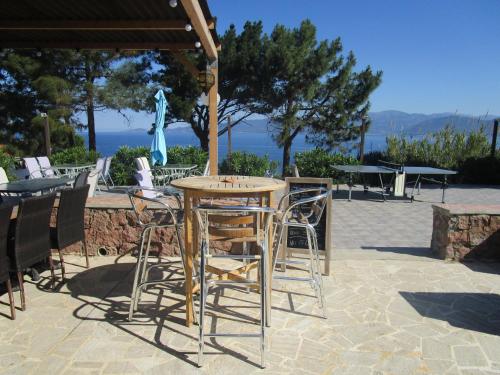 a table and chairs under an umbrella on a patio at Résidence Punta paliagi in Calcatoggio