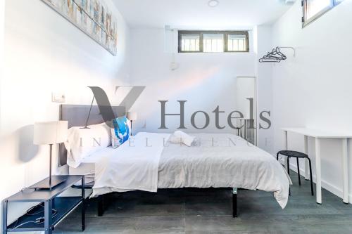 a white bedroom with a bed and a desk at AYZ Ulises - Auto check-in property in Madrid