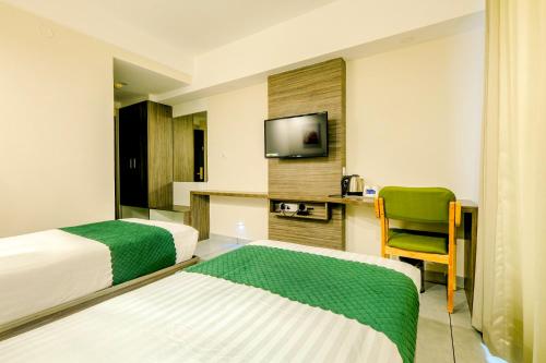 Habitación de hotel con 2 camas y TV en The HEARTLAND Hotel en Thiruvananthapuram
