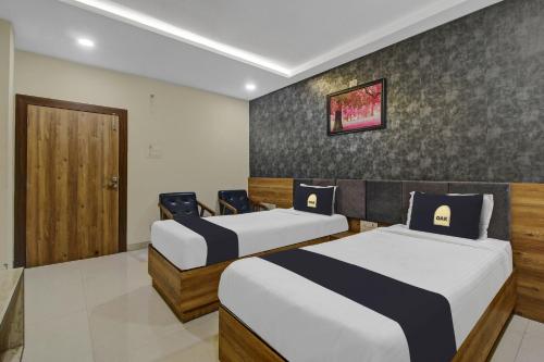 um quarto com duas camas e uma porta em Collection O Hotel Swagath Pride em Mancherāl