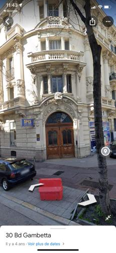 un bâtiment avec un conteneur rouge devant lui dans l'établissement Appartement T2 coconing, WIFI, INTERNET, CLIM, 300m plage, à Nice