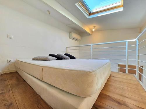 a large bed in a room with a skylight at Appartement T2 coconing, WIFI, INTERNET, CLIM, 300m plage in Nice