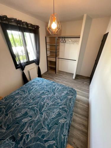 a bedroom with a bed with a blue comforter at Jolie Villa avec SPA et Balnéothérapie in Martignas-sur-Jalle