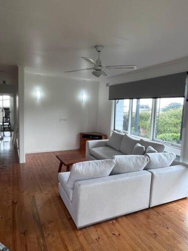 a living room with a white couch and windows at Happy Place @ The Prom in Yanakie