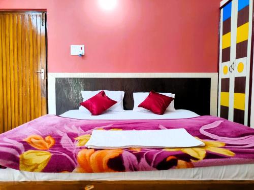 een slaapkamer met een bed met een roze muur bij Hotel Vaishnavi near Baba Dham Temple in Deoghar