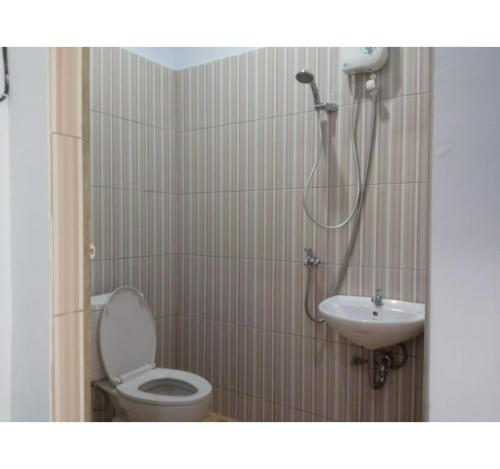 a bathroom with a shower and a toilet and a sink at OYO 93341 Ananda Homestay Syariah in Pekanbaru