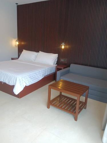 a bedroom with a bed and a table and a couch at Beach house by Rose massage in Nai Thon Beach