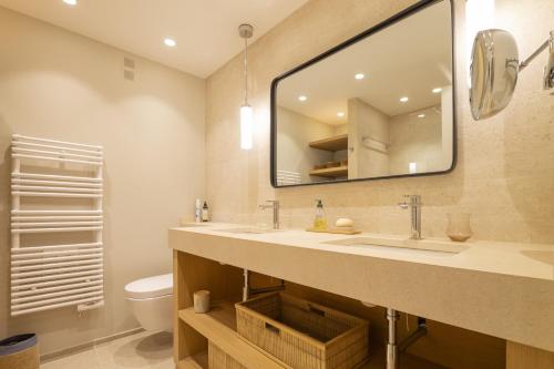 une salle de bain avec un lavabo et un miroir et des toilettes dans l'établissement Les Pins Tranquilles, à Cannes