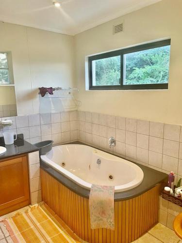 a large bathroom with a large tub in it at Manors' Holiday Home in Durban