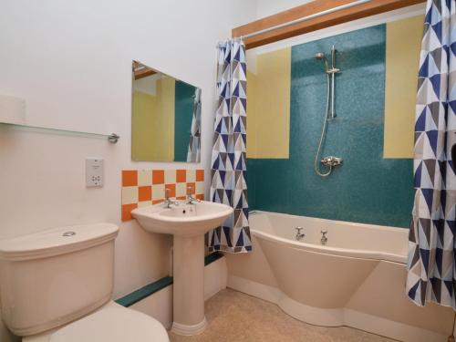 a bathroom with a sink and a toilet and a tub at 2 Bed in Sherborne FOLWO in Long Burton