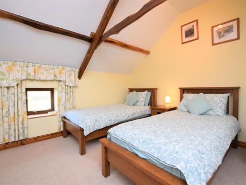 Frithelstock的住宿－3 bed property in Bideford HONEY，一间卧室设有两张床和窗户。