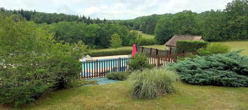 a blue fence in a yard with a house at Le Bos de Montassot in Savignac-les-Églises