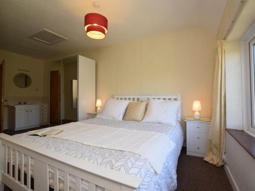 a bedroom with a large white bed and a window at 1 Bed in Kilve KILVE in Kilve