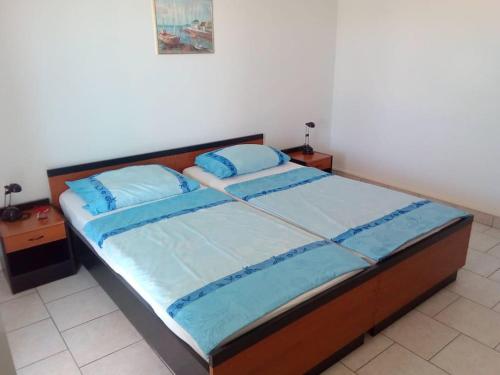1 dormitorio con 1 cama con sábanas azules y almohadas azules en Ferienhaus am Wasser - Kuća RiO - iberische Finca in Dalmatien, en Bilice