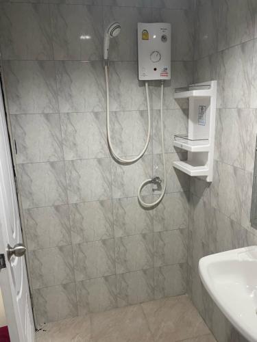 a shower with a shower head in a bathroom at Happy Apple Guesthouse in Pattaya Central