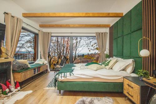 Un dormitorio verde con una cama grande y una ventana en Doza de Verde Chalet Bran en Sohodol