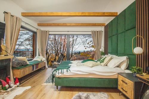 a green bedroom with a large bed and a window at Doza de Verde Retreat&Spa Bran-Adults Only in Sohodol