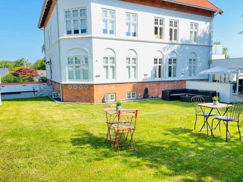 un patio con sillas y mesas frente a una casa en aday - City Central Mansion - 1 Bedroom with big terrace, en Aalborg