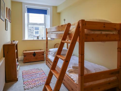 a bedroom with two bunk beds and a window at Number Seventeen in Amble