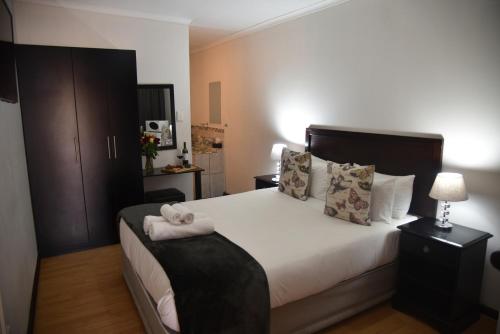 a bedroom with a bed with two towels on it at Arvella Guesthouse in Bloemfontein