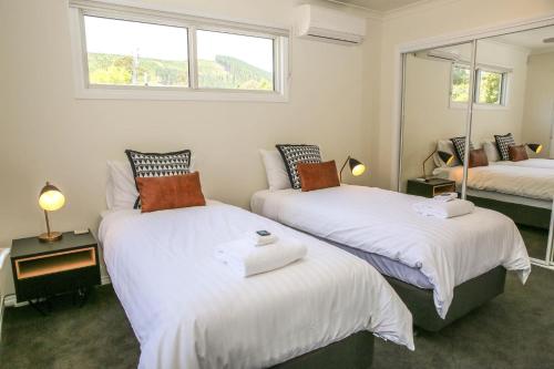a bedroom with two beds with white sheets and a window at Hidden Gem in Bright