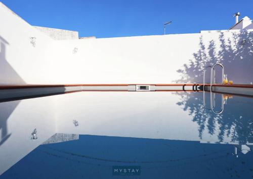 uma piscina com chuveiro e árvores ao fundo em MyStay - Casa dos Parentes em Igrejinha