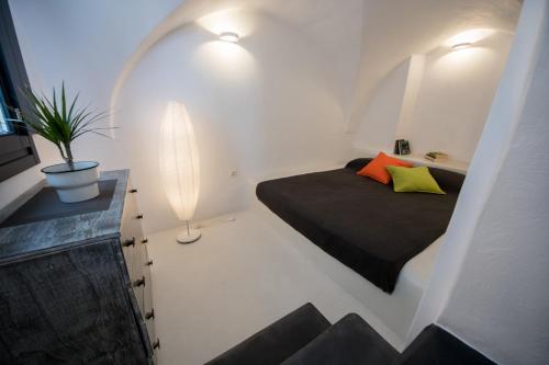 a small bedroom with a bed and a lamp at The Luna Suite with jacuzzi in Emporio Santorini