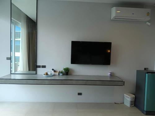 a living room with a flat screen tv on a wall at Beach house by Rose massage in Nai Thon Beach
