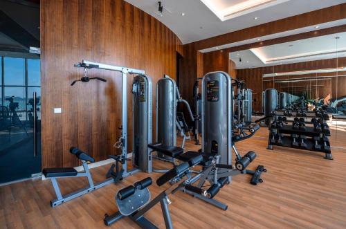 a gym with a row of treadmills and weights at Radisson Resort Ras Al Khaimah Marjan Island in Ras al Khaimah