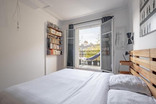 une chambre avec un grand lit blanc et une fenêtre dans l'établissement Veeve - Spire View, à Paris