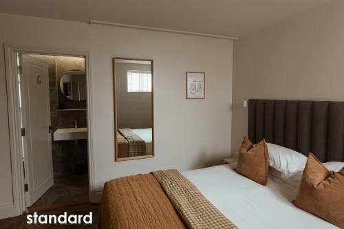 um quarto de hotel com uma cama e um espelho em HIDEOUT Hotel em Hull